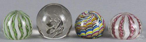 Four art glass paperweights, to include two Murano style ribbon and latticino paperweights