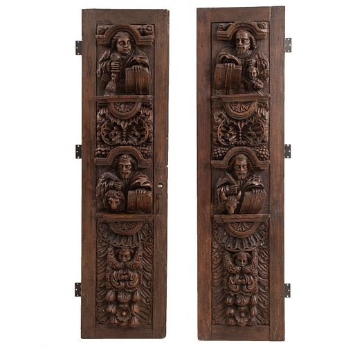 Par de puertas de iglesia. México, SXX. Elaboradas en madera tallada. Representaciones de los 4 evangelistas y amorcillos.