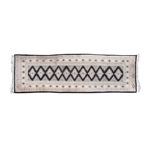 Tapete de pasillo. Origen oriental, SXX. Estilo Bokhara. Elaborado en fibras de lana y algodón. Anudado a mano.