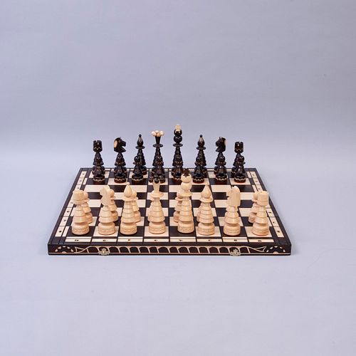 Juego de ajedrez. Siglo XX. Elaborado en madera. Tablero pirograbado y trebejos  entintados. Total de piezas: 33. 60 x 60...