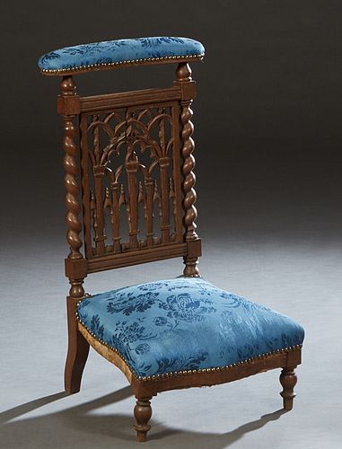 French Carved Oak Gothic Style Prie Dieu, 19th c., the upholstered cushioned arm rest over a pierced Gothic arch splat, flanked by rope twist supports