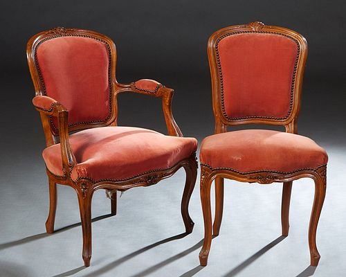 Two French Carved Beech Parlor Chairs, early 20th c., consisting of a fauteuil and a side chair, the arched canted floral carved shield back, to an up