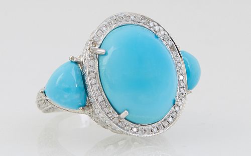 Lady's 14K White Gold Dinner Ring, with a central large oval cabochon turquoise atop a border of round diamonds, with diamond mounted edges, flanked b