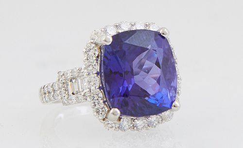 Lady's Platinum Dinner Ring, with a 13.19 carat cushion cut tanzanite, atop a conforming border of round diamonds, flanked by baguette and round diamo