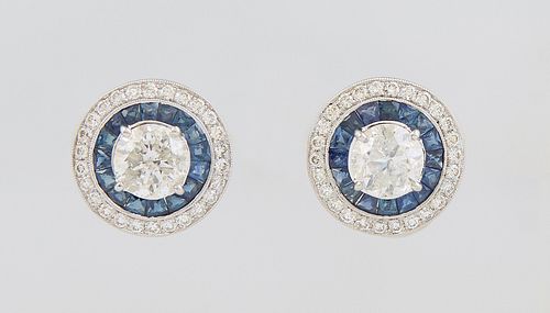 Pair of 14K White Gold Pierced Circular Earrings, with central 1.51 ct. round diamonds atop a border of trapezoidal and round blue sapphires, within a