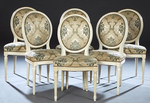 Set of Six French Louis XVI Style Carved Beech Dining Chairs, 20th c., the canted cushioned oval medallion back over a bowed upholstered seat, on turn