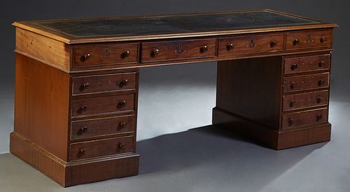 English Carved Mahogany Desk, 20th c., the rectangular ogee top with an inset gilt tooled leather writing surface, over four frieze drawers above two 