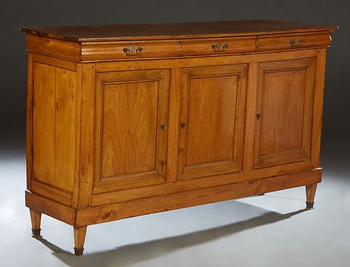 French Louis XVI Style Carved Cherry Sideboard, 19th c., the rounded edge rectangular top over three cavettto frieze drawers above three cupboard door
