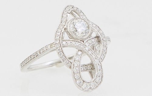 Lady's Platinum Dinner Ring, the pierced top with a .32 ct. round diamond and numerous tiny round diamonds, the shoulders of the band also mounted wit