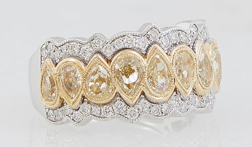 Lady's 18k White Gold Dinner Ring, the wide top with a central row of 9 vertical pear shaped yellow diamonds, bordered on both sides by a scalloped fr