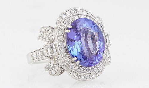 Lady's Platinum Dinner Ring, with an oval 6.64 ct. tanzanite atop a border of tiny round white diamonds and an outer top and bottom cap of tiny round 