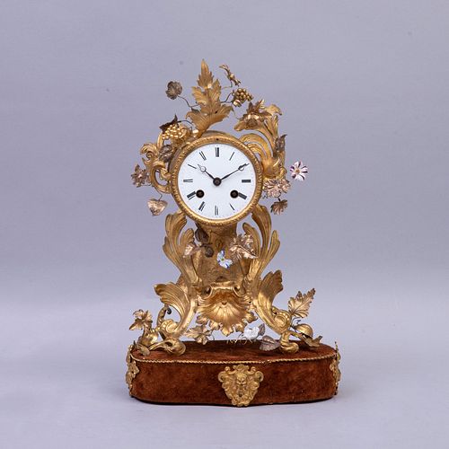 Reloj de mesa Francia, siglo XX Elaborado en metal dorado y porcelana . Carátula circular. Decorado con elementos florales.