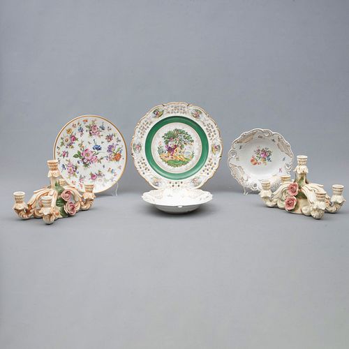 Lote de 2 candelabros y 4 platos. Alemania SXX. Elaborados en cerámica y porcelana. Decorados con motivos florales.