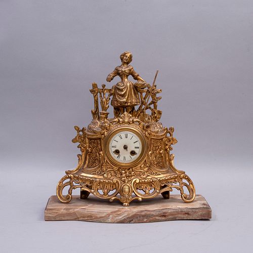 Reloj de chimenea. SXX. Elaborado en metal dorado. Con base de ónix. Con carátula blanca e índices romanos. 37 cm altura.