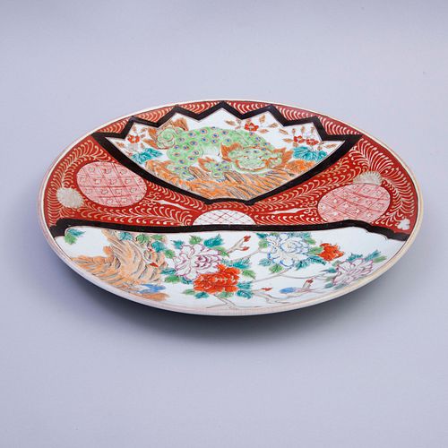 PLATÓN. China, SXX. Elaborado en porcelana, decoración policromada, con diseños a manera de Perro Fo y aves en enramada. 41 cm de diam.