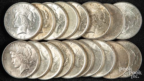 Eighteen Peace silver dollars.