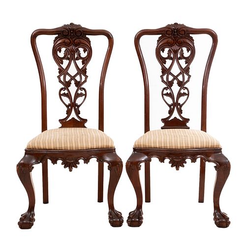 Par de sillas. SXX. Elaboradas en madera. Con asientos acojinados de tela, respaldos semiabiertos y soportes tipo garra.