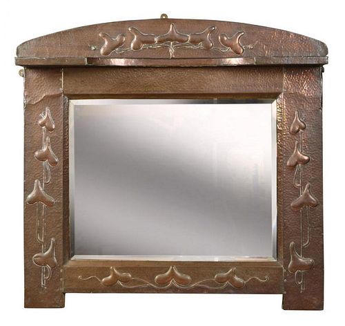 An Art Nouveau copper framed overmantle mirror, the repoussé frame with rounded top and embossed sty
