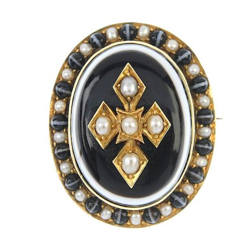 A mid Victorian gold banded agate and split pearl memorial brooch. Of oval outline, the banded agate
