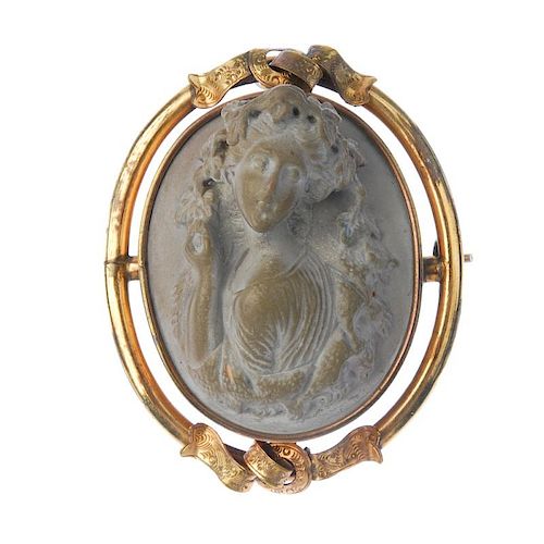 A lava cameo brooch. The grey-tone lava carved to depict a Bacchante, with vine leaves through her h