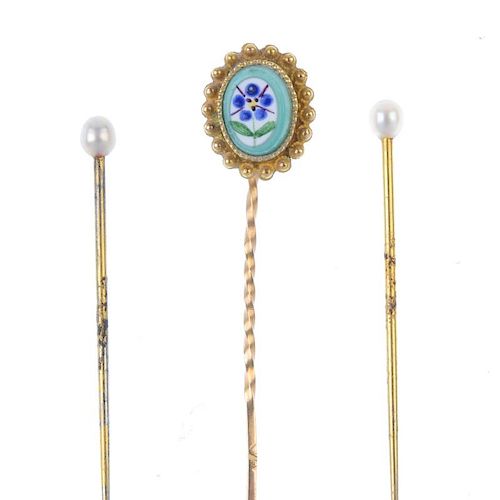 A set of three stickpins. To include a gold stickpin with oval-shape glass panel painted with a flow