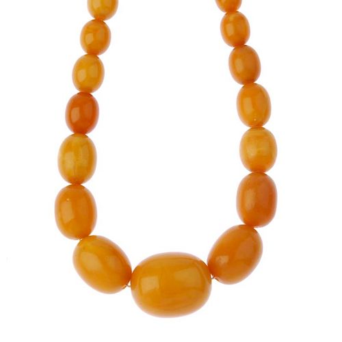 A natural amber bead necklace. Designed as a single row of forty-nine graduated oval-shape natural a