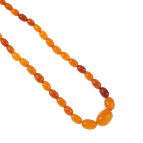 A natural amber bead necklace. The seventy-one oval-shape graduated beads, measuring 0.8 to 2.2cms.