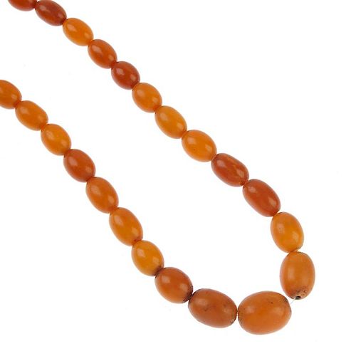 A natural amber necklace. Comprising sixty-three graduated oval-shape natural amber beads, measuring