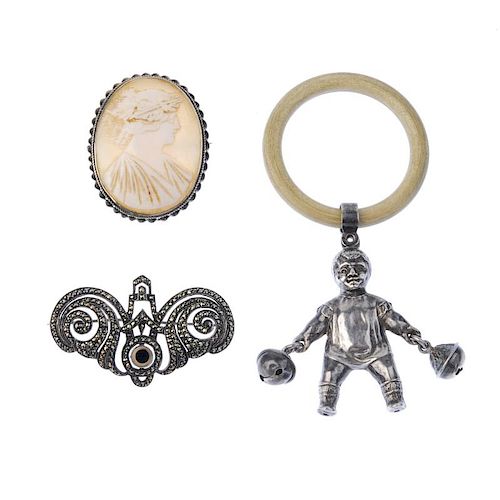 A selection of silver items. To include a child's rattle, designed as a baby carrying a bell in eith