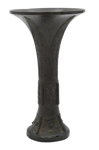 Chinese Bronze Gu, drinking vessel decorated in typical Shang style with inverted blades and Taotie mask, 16th/17th century, height 8 1/4 inches.