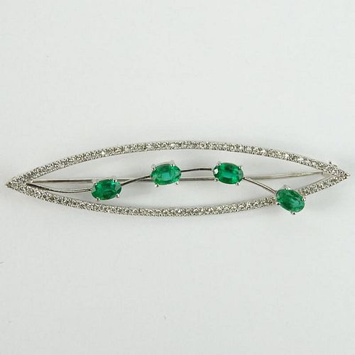 Lady's Vintage Oval Cut Emerald and 14 Karat White Gold Brooch accented throughout with Small Round Cut Diamonds.