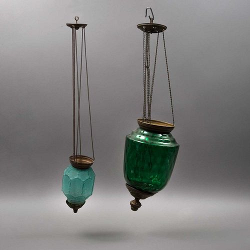 PAR DE LÁMPARARAS VOTIVAS. CA. 1900. Vidrio flotado y vidrio prensado, tonos azul y verde. Pantallas: 14.5 y 24 cm de altura.
