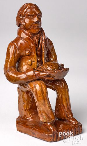 Rare modeled redware figure of a seated man