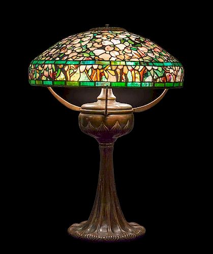 A Tiffany Studios Favrile Glass and Bronze Dogwood Lamp, Height overall 25 x diameter of shade 18 inches.