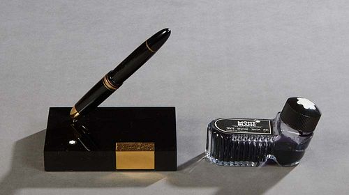 Mont Blanc Meisterstuck Fountain Pen in a desk top holder, with an 18K yellow gold nib, and a partial bottle of Mont Blanc ink. Provenance: Property f