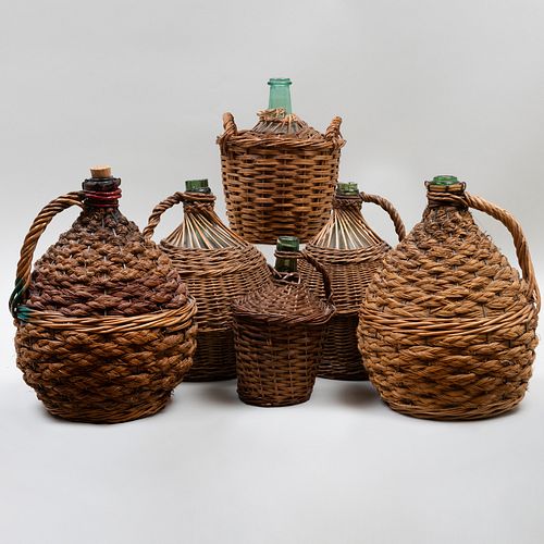 Group of Five Wicker Mounted Glass Demijohns