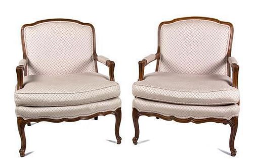 A Pair of Louis XV Style Carved Walnut Fauteuils Height 34 1/2 inches.