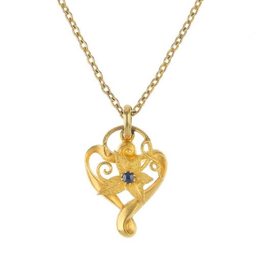 An Edwardian 15ct gold sapphire floral pendant. The textured flower with circular-shape sapphire hig