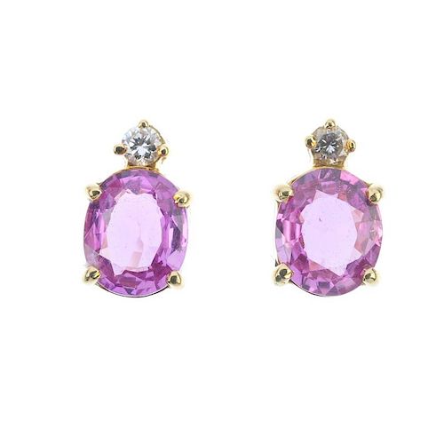A pair of sapphire and diamond ear studs. Each designed as an oval-shape pink sapphire, with a brill