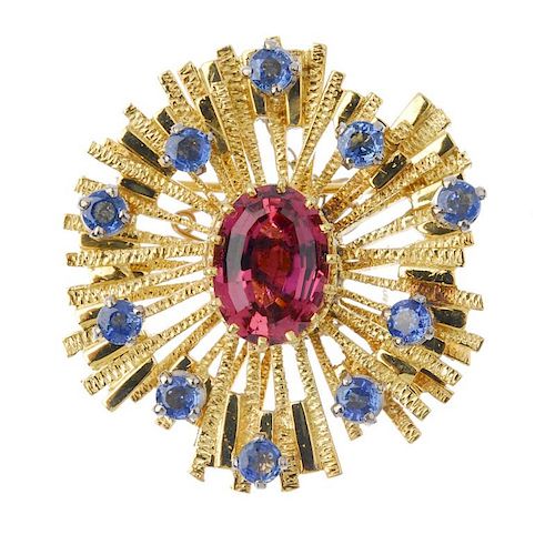 A mid 20th century tourmaline and sapphire brooch. The oval-shape pink tourmaline, within a circular