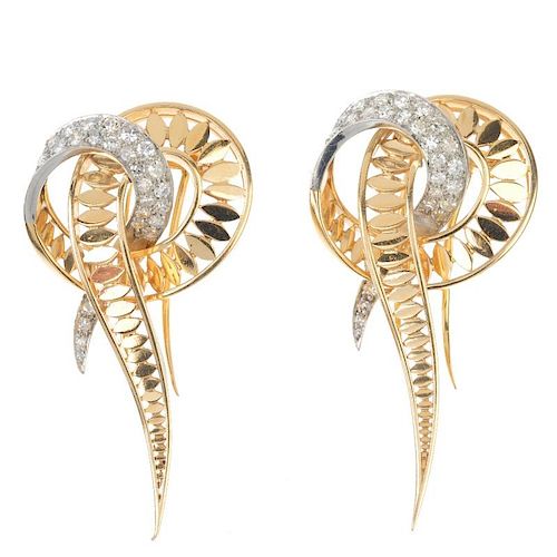 A pair of 1970s diamond clips. Each designed as an openwork stylised knot with pave-set diamond acce
