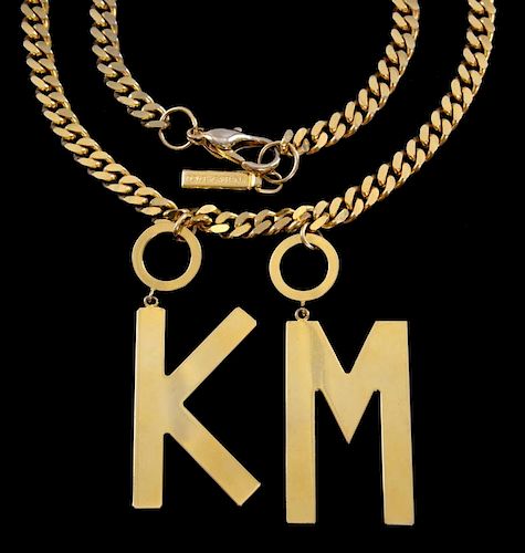 Kylie Minogue, A 'gold plated' flat curb link chain necklace with suspended twin pendants of initial
