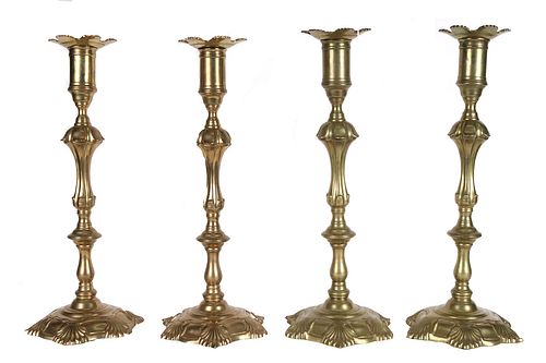 Four George III Cast Brass Shell Base Candlesticks