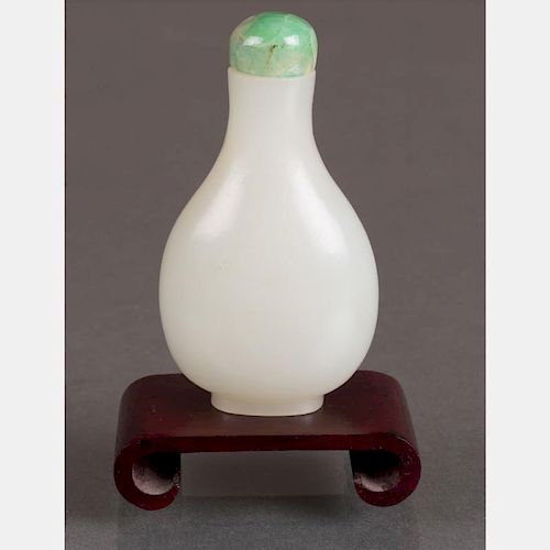 A White Jade Snuff Bottle with Green Jade Stopper on Carved Hardwood Stand.