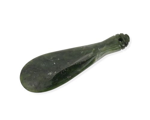 A carved green stone short club