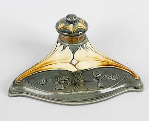 A German Art Nouveau porcelain inkstand, with pen tray before the raised and covered inkwell, the wh