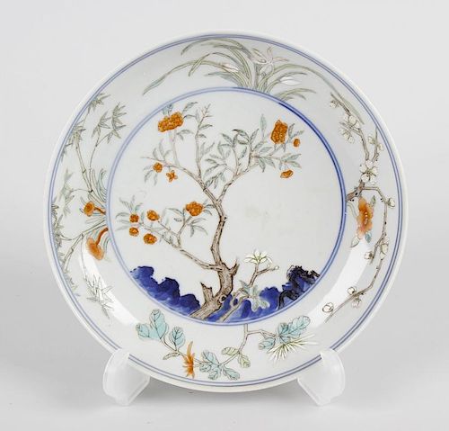 A Chinese porcelain saucer, with central hand painted scene of blossoming tree, within a border depi