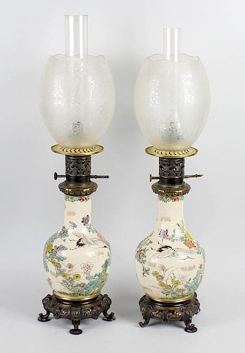 A pair of Japanese satsuma oil lamps, each having frosted glass ovoid shade with wavy rim over the b