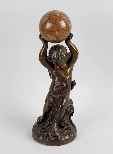 A late 19th century bronze study of a putto with hand held aloft, holding a marble sphere, seated up