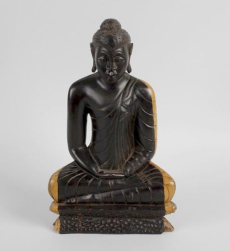 An Eastern carved hardwood study depicting a Buddha in seated pose with crossed legs, his arms place